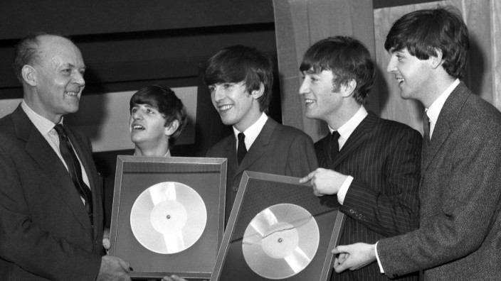EMI: Der damalige EMI-Chef Joseph Lockwood überreicht den Beatles 1963 in London silberne Schallplatten.