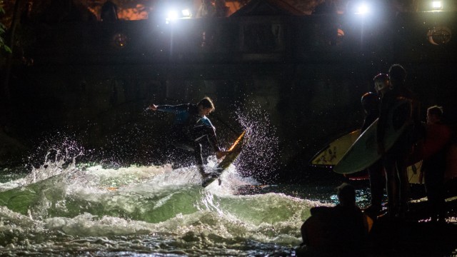 Sightseeing: Junge Surfer trainieren in der Nacht auf der Eisbachwelle in München.