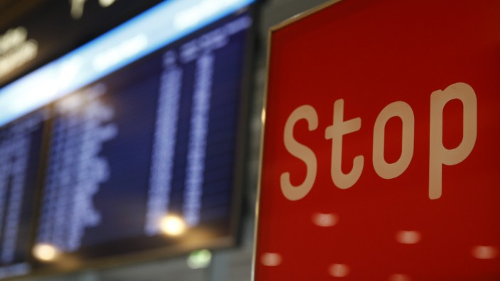 A sign reading Stop stands in front of an electronic information board following a security alert at Cologne airport