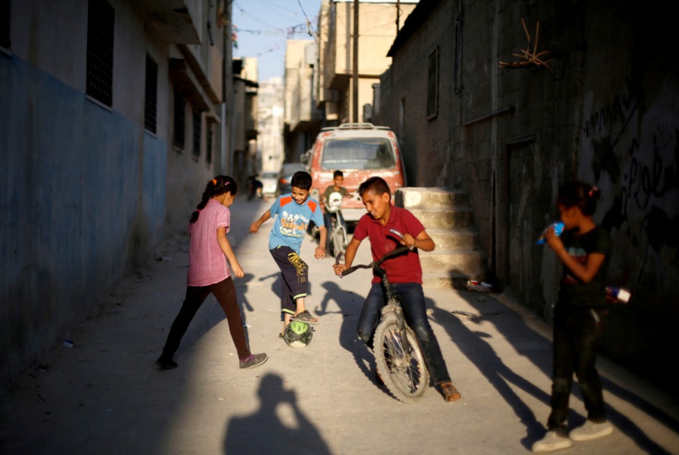 Palestinian refugee children play in street during the holy month of Ramadan, in Al-Baqaa Palestinian refugee camp, near Amman