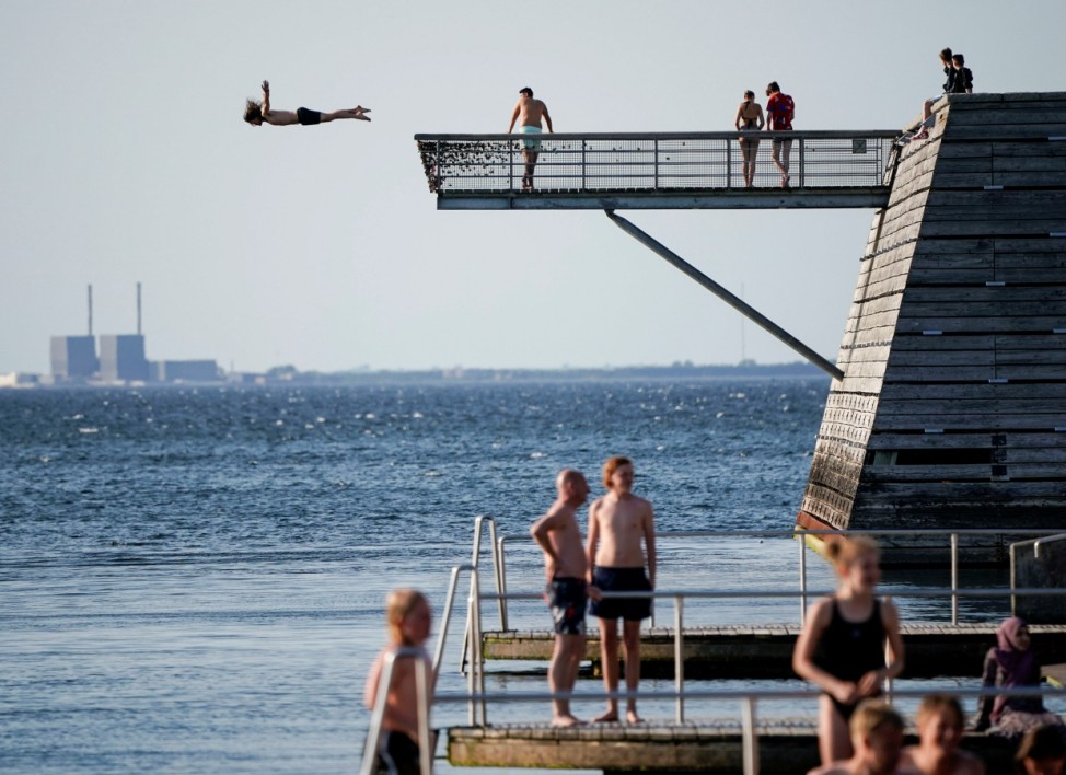 A young man dives off a diving tower at the Titanic Pier in Malmo