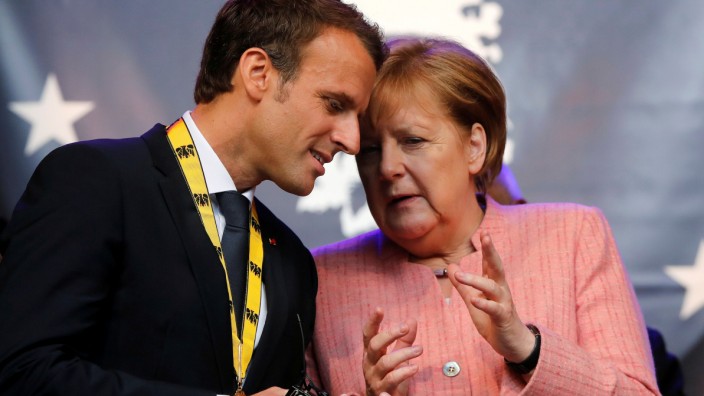 FILE PHOTO: French President Macron and German Chancellor Merkel wave after Macron was awarded Charlemagne Prize in Aachen