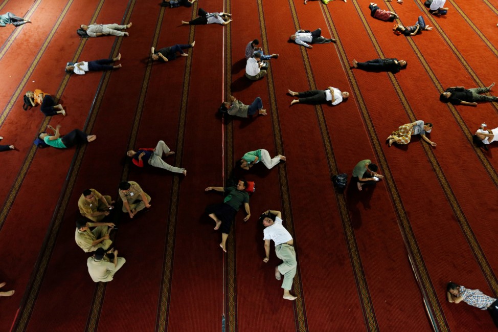 People sleep as they wait for iftar during the holy month of Ramadan at Istiqlal mosque in Jakarta