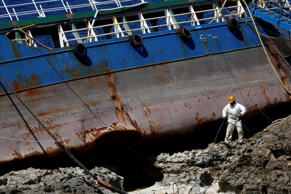 A salvage worker takes part in the salvage operation of the Togo-registered, 885-tonne bunker tanker Hephaestus, which ran aground last February, in Qawra