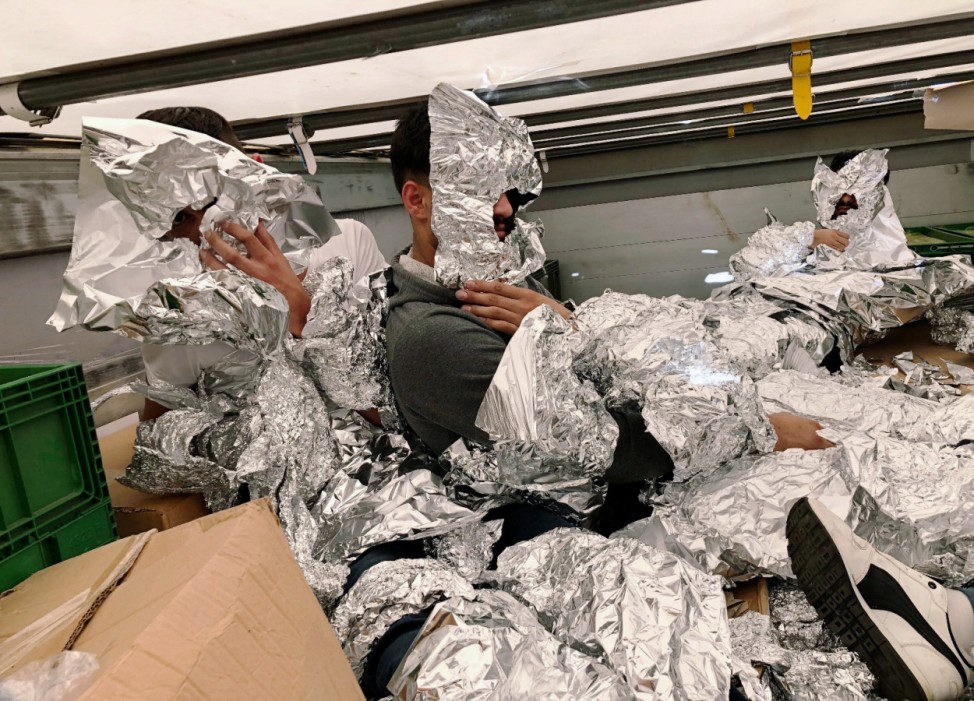 3 of the 7 Iraqi refugees wraped in aluminium foil to hide from an x-ray detector are pictured inside a truck at Pendik Port as they try to reach Italy in Istanbul