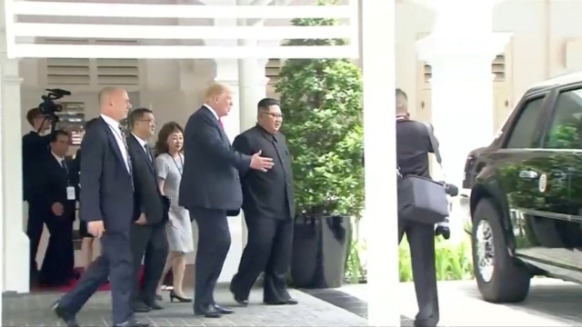 U.S. President Donald Trump shows North Korean leader Kim Jong Un his car, nicknamed 'The Beast', during their walk around Capella hotel after a working lunch at a summit in Singapore