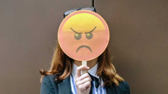 Woman hiding face behind emoji mask model released Symbolfoto property released PUBLICATIONxINxGERxS
