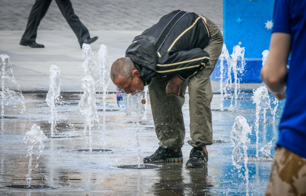Ein Mann trinkt an einem Brunnen in Jekaterinburg