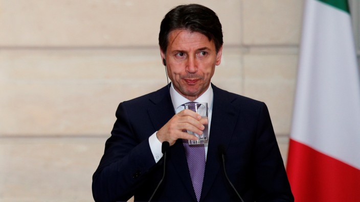 Italian Prime Minister Giuseppe Conte holds a glass of water during a joint news conferenece with French President Emmanuel Macron (not pictured) at the Elysee Palace in Paris