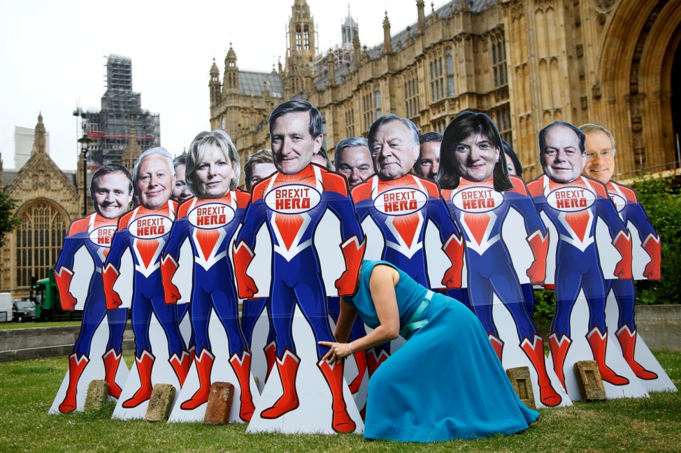 An anti-Brexit campaigner from global activism group Avaaz sets up cardboard cut-outs of Conservative Party MPs, who are known to support remaining in the EU, outside parliament in Westminster in London