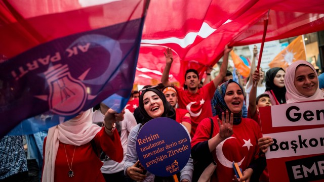 Türkei: Eine Anhängerin der AKP schwingt eine Fahne mit dem Parteilogo (links).