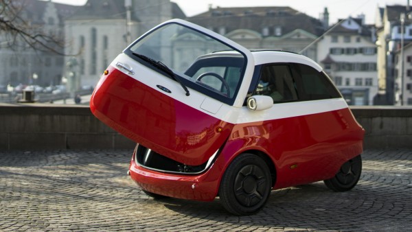 Elektroauto Microlino im Stil der BMW Isetta mit offener Kühlschranktür.