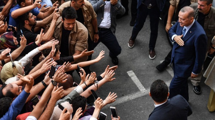 Wahl in der Türkei: Nach getaner Arbeit: Der türkische Präsident Recep Tayyip Erdoğan wird beim Verlassen seines Wahllokals in Istanbul von begeisterten Anhängern empfangen.