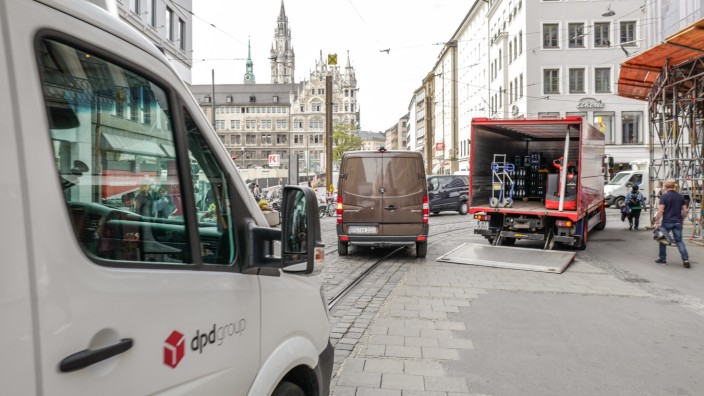 Auf der Theatinerstraße fährt ein Transporter an einem Laster vorbei.