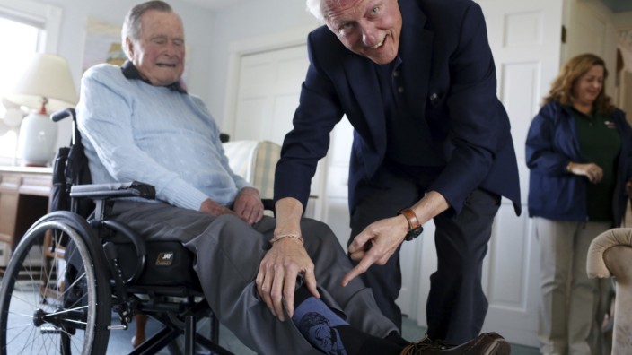 Ehemaliger US-Präsident: Begutachtet sein eigenes Konterfei auf der Socke: Ex-Präsident Bill Clinton zu Besuch bei Ex-Präsident George Bush.