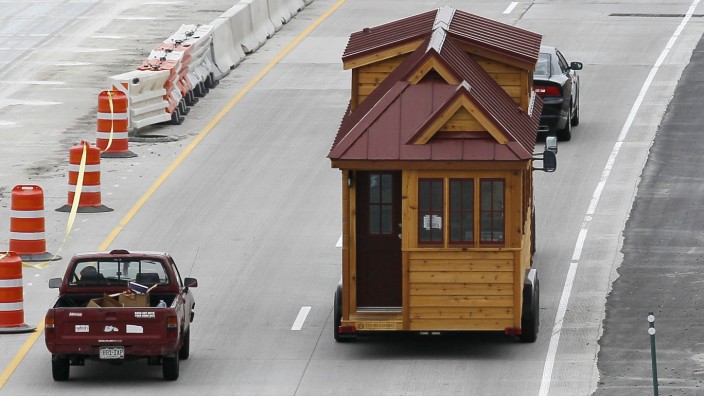 A Tumbleweed brand Cypress 24 model Tiny House is towed down the highway near Boulder
