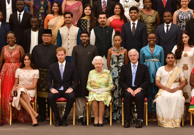 Britain's Queen Elizabeth, Prince Harry and Meghan, the Duchess of Sussex pose for a picture with some of Queen's Young Leaders at a Buckingham Palace reception following the final Queen's Young Leaders Awards Ceremony, in London