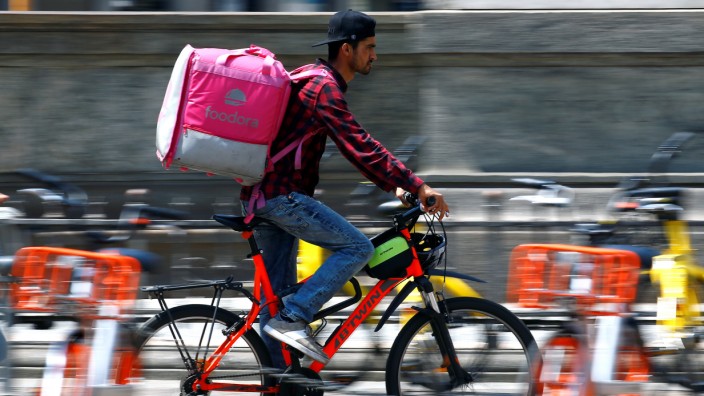 A food delivery driver for Foodora cycles in downtown Milan