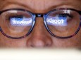 FILE PHOTO: The Facebook logo is reflected on a woman's glasses in this photo illustration