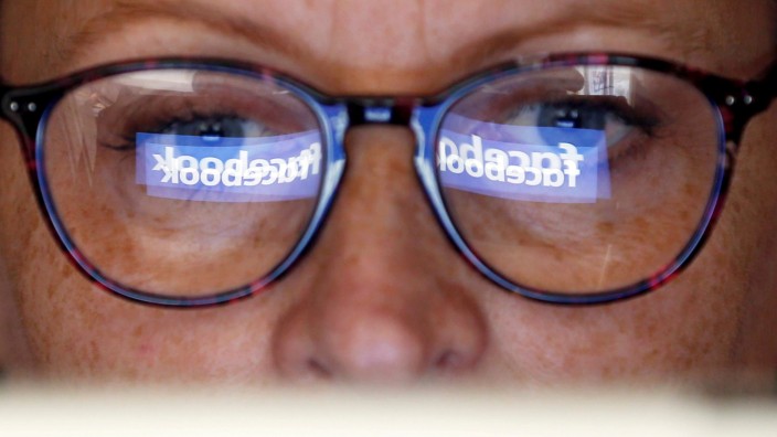 FILE PHOTO: The Facebook logo is reflected on a woman's glasses in this photo illustration
