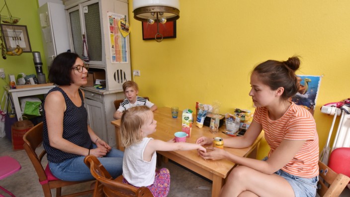 Münchner Wohnungsmarkt: Julia Timmons (links) sitzt mit ihren Kindern Tilda und Oskar in der Küche. Ohne die Untermiete von Sabina Orazov könnte sie sich die Wohnung als Alleinerziehende nicht mehr leisten.