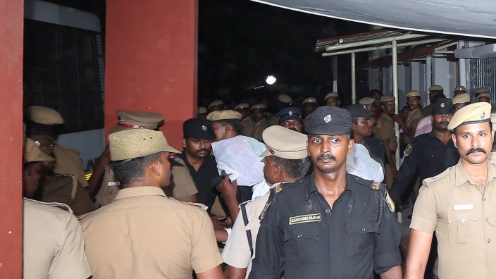 Police escort one of the men (face covered) accused of raping a 12-year girl inside the high court premises in Chenna