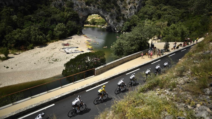 Tour de France: Immer der Reihe nach: Der Gesamtführende Geraint Thomas vom Team Sky passiert im Gelben Trikot die Pont d'Arc über der Ardèche. Auch nach der 14. Etappe führt Thomas im Gesamtklassement vor seinem Teamkollegen Chris Froome.