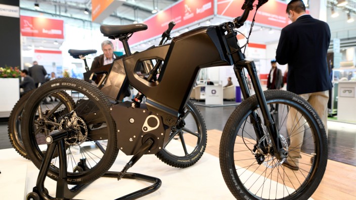 FILE PHOTO: Visitors pass an E-Bike at the Hannover Messe, the trade fair in Hanover