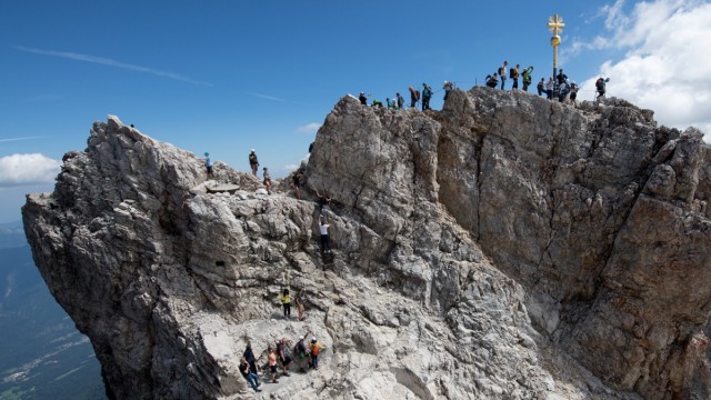 Bergsteiger und Touristen am Gipfelkreuz der Zugspitze