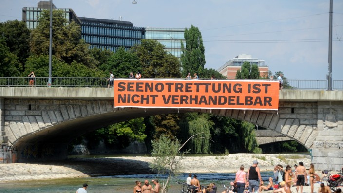 Unter der Reichenbachbrücke: Aktivisten der "Seebrücke" protestieren an der Reichenbachbrücke mit einem Transparent und werfen Rettungswesten in die Isar. Sie wollen daran erinnern, dass nach wie vor täglich Flüchtlinge im Mittelmeer sterben.