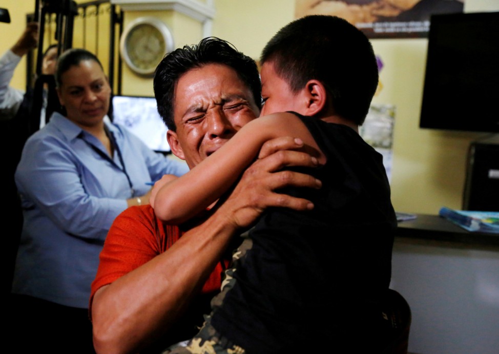 Estanislao Perez hugs his son Keidin, who was sent back from detention on Tuesday, after they were separated at the U.S. border, in Guatemala City