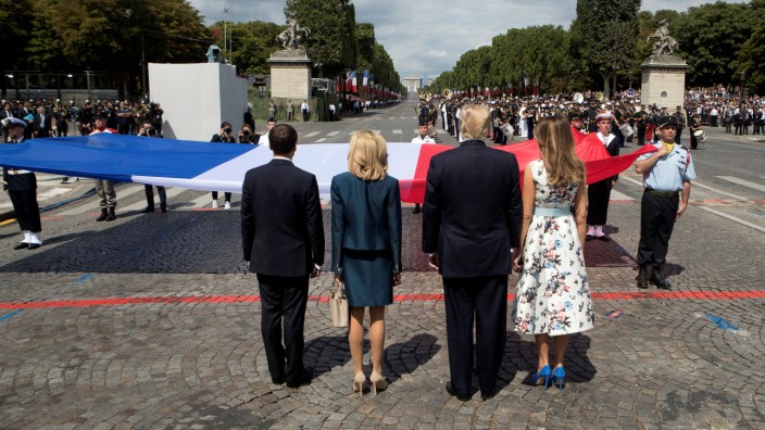 US President Donald Trump and First Lady Melania Trump bid adieu after viewing France's Bastille Day military parade on the Champs-Elysees as the guests of French President Emmanuel Macron and his wife Brigitte Macron, in Paris