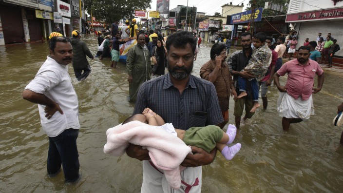 Überschwemmungen in Südindien PATHANAMTHITTA INDIA AUGUST 18 A man carrying a child through the