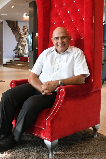 Mittwochsporträt: David Fattal, der Mann auf dem roten Stuhl, ist Hotelkettenbesitzer und meistens unterwegs. Hier besucht er gerade eines seiner Leonardo-Hotels am Stadtrand von München.