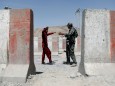 An ANA soldier inspects a passenger at a checkpoint on the Ghazni - Kabul highway