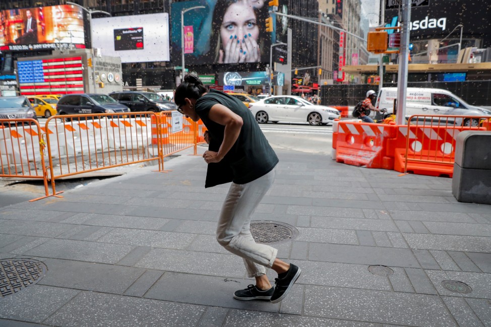 People react to a swarm of bees in Times Square in New York