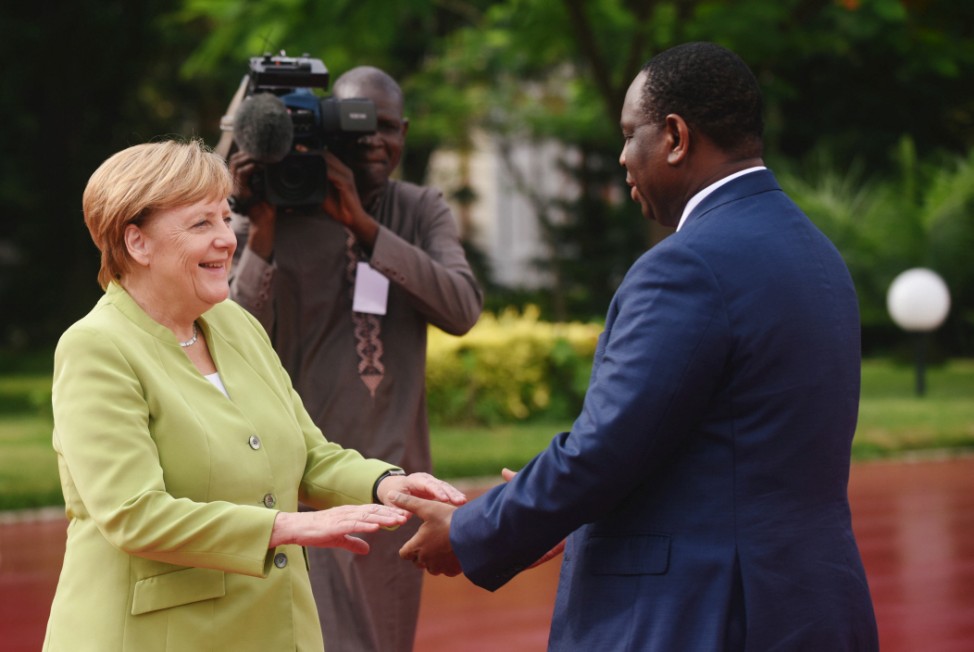 German Chancellor Angela Merkel is greeted as she arrives at the Presidential Palace by Senegal's President Macky Sall in Dakar