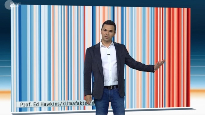 Klima und Wetterbericht: Der ZDF-Wettermoderator Özden Terli mit den "Warming Stripes" für Deutschland am Ende des Heute Journals am 18. Juli 2018. Jeder Streifen zeigt die Durchschnittstemperatur eines Jahres an.