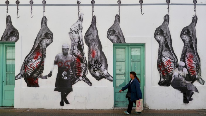 A woman walks outside a restaurant in Buenos Aires