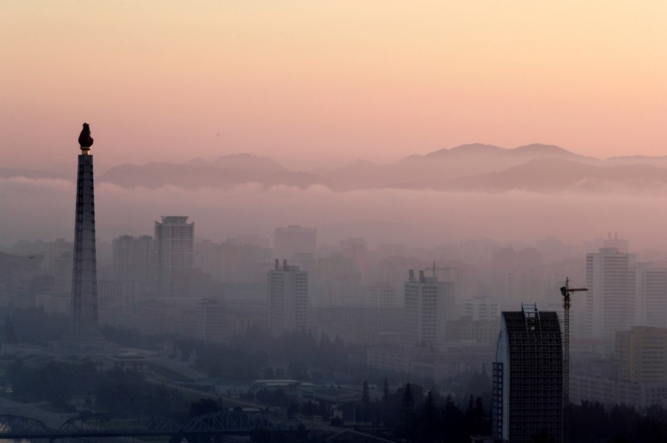 The 170-metre (558-feet) tall Juche Tower and other buildings are seen as morning fog blankets Pyongyang
