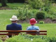 Zwei Rentner sitzen in Bad Wörishofen auf einer Parkbank