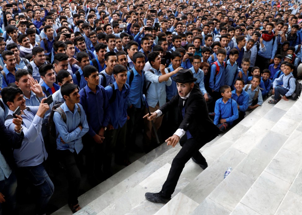 Afghanistan's Charlie Chaplin, Karim Asir, 25, performs at a school in Kabul