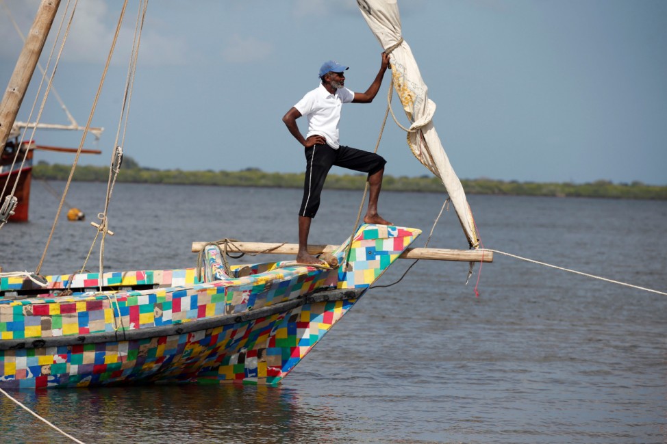 Man stands on the front of Flipflopi the first dhow boat made entirely of recycled plastic during its launch ceremony on the island of Lamu