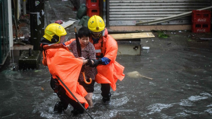 Wetter: Einsatzkräfte retten eine Frau am Wochenende in den überfluteten Straßen von Hongkong.