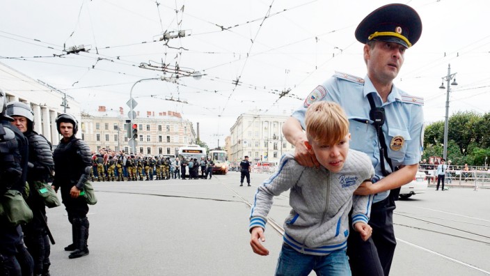 Framing-Check: "Illiberale Demokratie": Demonstrieren verboten: Ein Polizist führt in Sankt Petersburg einen Jugendlichen bei Protesten gegen Putins geplante Rentenreform ab.