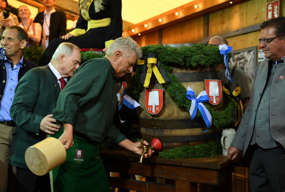 Munich mayor Dieter Reiter prepares to tap the first barrel of beer during the opening ceremony of the 185th Oktoberfest in Munich