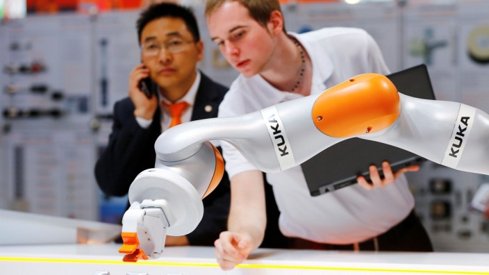 FILE PHOTO: A Kuka technician programs a robot arm of German industrial robot maker Kuka in Hanover