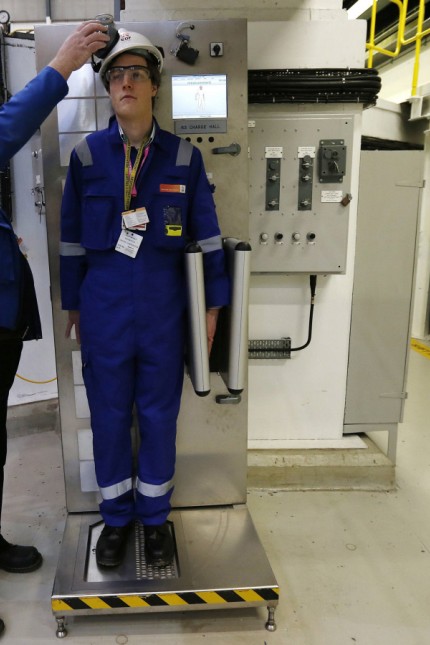 An environmental safety monitor scans an employee during a contamination checks in the charge hall inside EDF Energy's Hinkley Point B nuclear power station in Bridgwater, southwest England