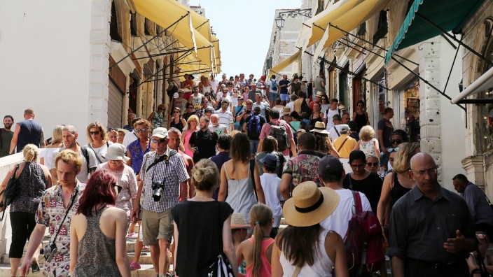 Touristen gehen über die Rialtobrücke in Venedig.