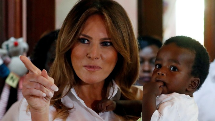 U.S. First Lady Melania Trump holds a child at  The Nest Children's Home in Nairobi